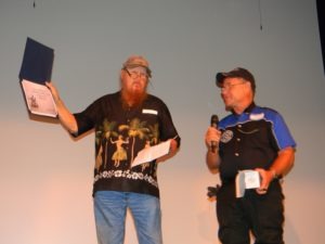 Mickey jones received an honorary certificate of membership to the VMMC from harry Fisher onstage after the screening