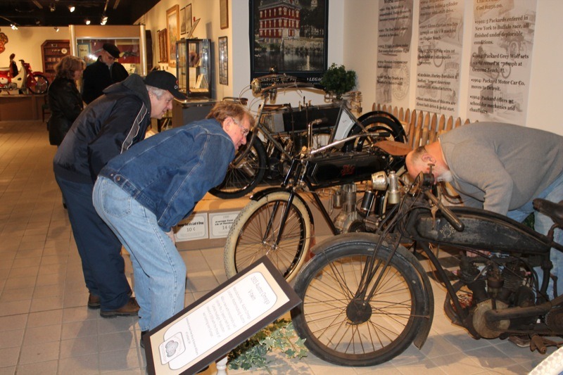 Rich Adams and Ron Lemendola talk old bikes with curator Bruce Williams (r)