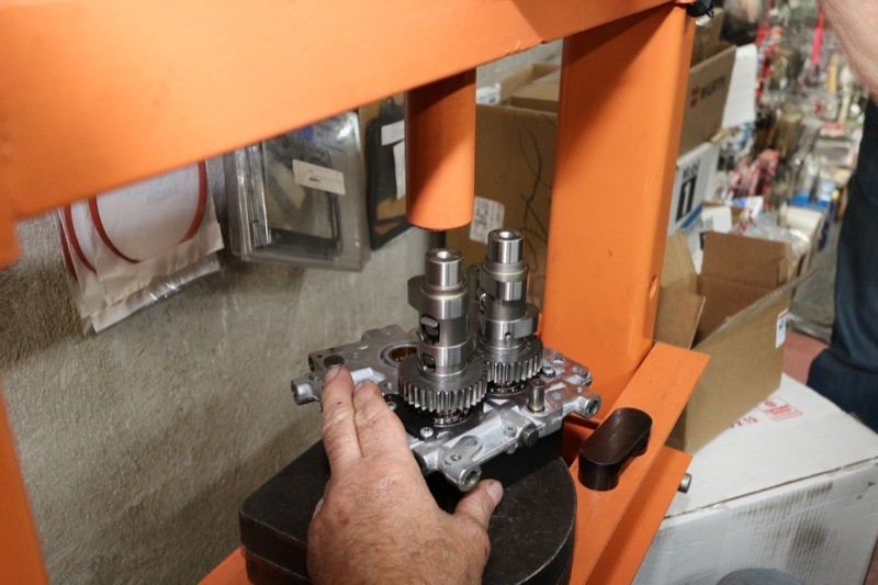 Ken uses a hydraulic press to install the cams into the cam plate