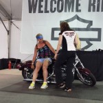 A Harley rep shows this lady how to pick up a downed scoot