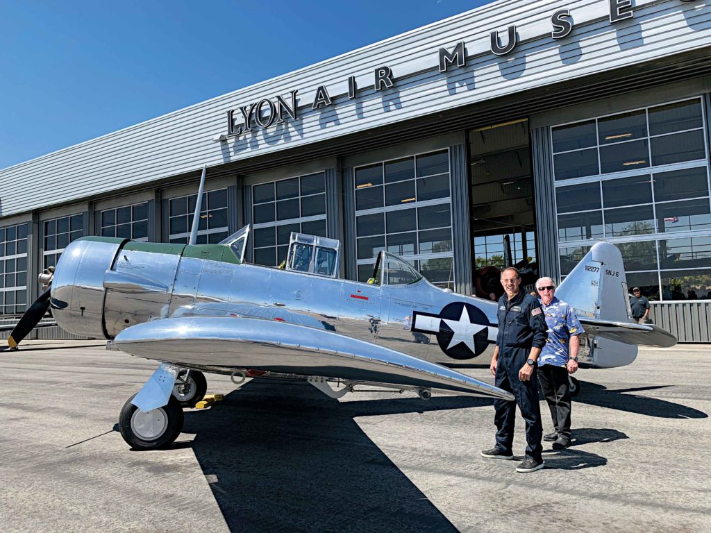 Rich Lewis (right), the winner of the people’s choice award with his 1965 Harley-Davidson Electra Glide, prepares to take a flight of a lifetime with Lyon Air Museum President Mark Foster.